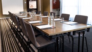 A conference room with a long table, chairs, water bottles, and glasses. There is a whiteboard and a fire extinguisher visible. - The Raphael Vienna Hotel, a member of Radisson Individuals Boutique (Vienna)