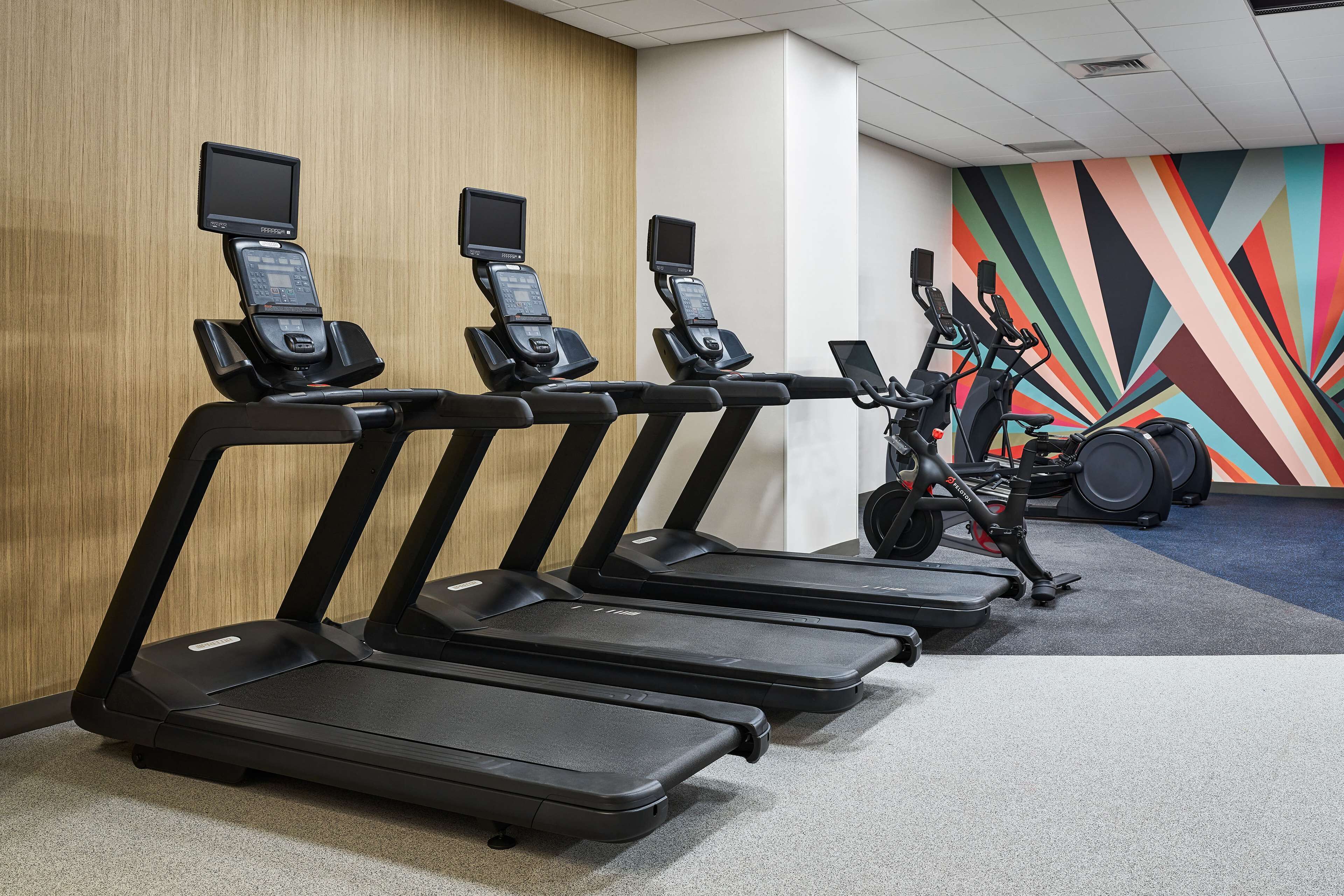Una palestra con diverse tapis roulant e una cyclette ellittica.