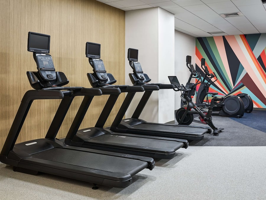 A gym with multiple treadmills and an elliptical machine.