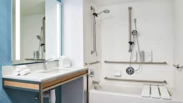 Une salle de bain moderne avec un lavabo, un miroir et un espace douche.