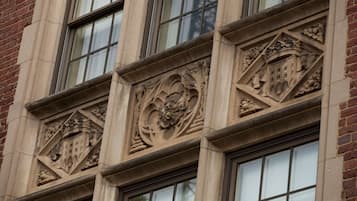 Une façade d’immeuble ornée de sculptures en pierre et dotée de nombreuses fenêtres.