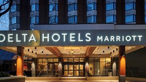 The exterior of a Delta Hotels Marriott building with a modern design, featuring a prominent entrance and a glass facade. - Delta Hotels by Marriott Toronto Mississauga (Mississauga)