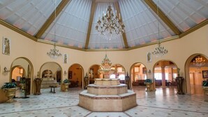 A spacious hall with a high, vaulted ceiling and multiple chandeliers.