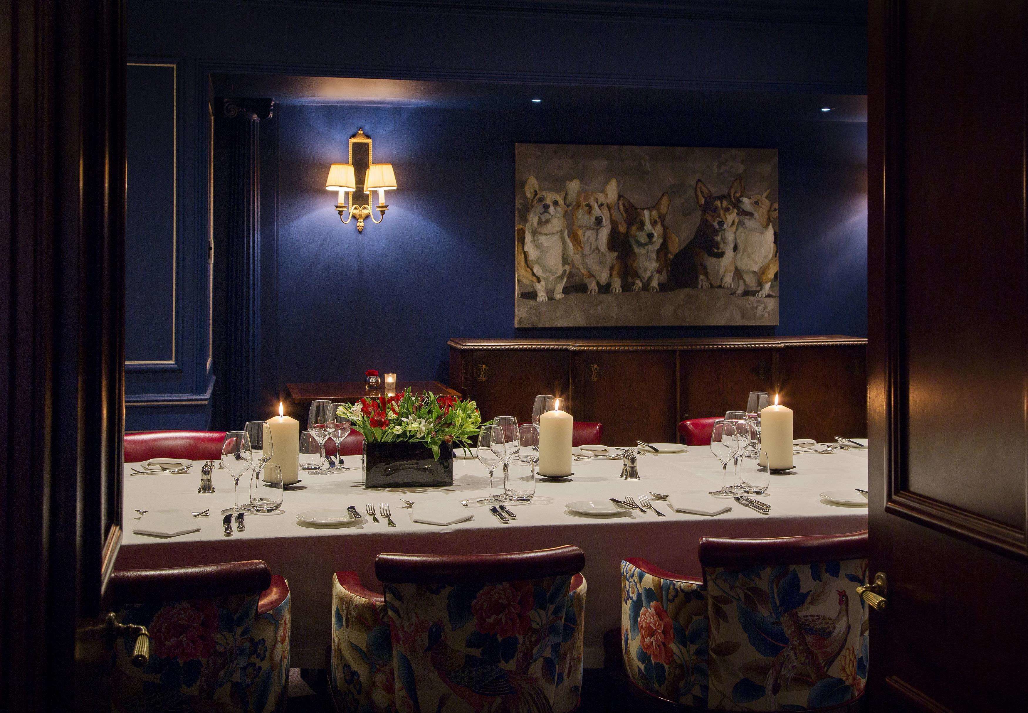 Ein Esszimmer mit Tisch für vier Personen, Kerzen und floralen Mittelpunkten.