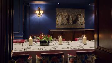 Ein Esszimmer mit Tisch für vier Personen, Kerzen und floralen Mittelpunkten.
