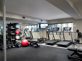 Ein Fitnessraum mit Laufbändern, Kraftgeräten und einem roten Trainingsball.