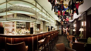 Zona de bar con diversas opciones de asientos y exhibición de diferentes botellas.
