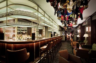 Eine Bar mit verschiedenen Sitzgelegenheiten und einer Auswahl an Flaschen.