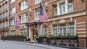 Un edificio histórico con una entrada destacada, banderas y una fachada bien conservada.