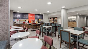 A modern restaurant with tables and chairs, a waffle station, and a counter with a menu. - Hampton Inn Bridgeport/Clarksburg (Bridgeport)