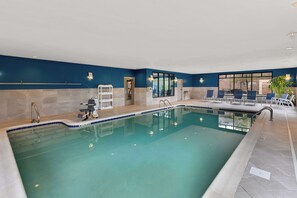 An indoor swimming pool with clear water, a tiled deck, and lounge chairs. - Hampton Inn Bridgeport/Clarksburg (Bridgeport)