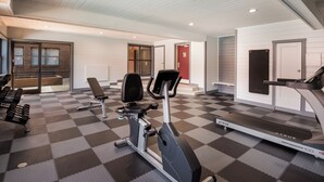 A gym with exercise equipment, a treadmill, and a checkered floor.