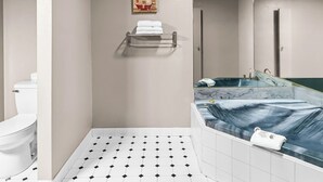 A bathroom with a toilet, a shower, and a bathtub. There is a towel rack on the wall and a painting above the shower. - Red Roof Inn & Suites Lexington - Hamburg (Lexington)