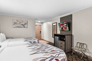 A hotel room with two beds, a television, a desk with drawers, a chair, and a door in the background. - Red Roof Inn & Suites Lexington - Hamburg (Lexington)