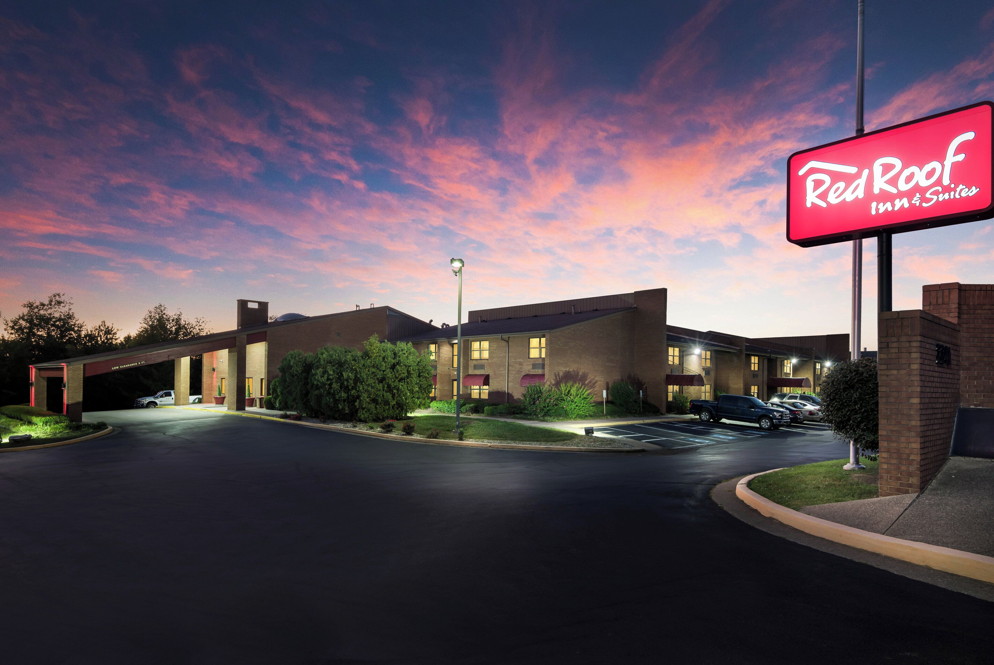 A Red Roof Inn & Suites with a parking lot and a building entrance.