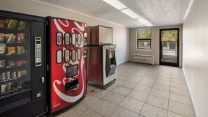 A vending machine with various snacks and a Coca-Cola branded machine.