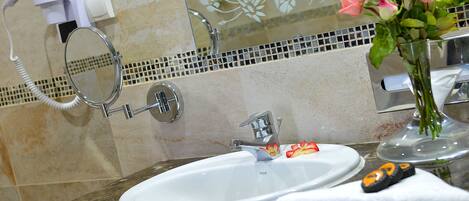 A bathroom with a sink, mirror, and a hairdryer.