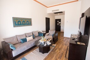 Una sala de estar con sofá, mesa de centro y mueble para televisión.