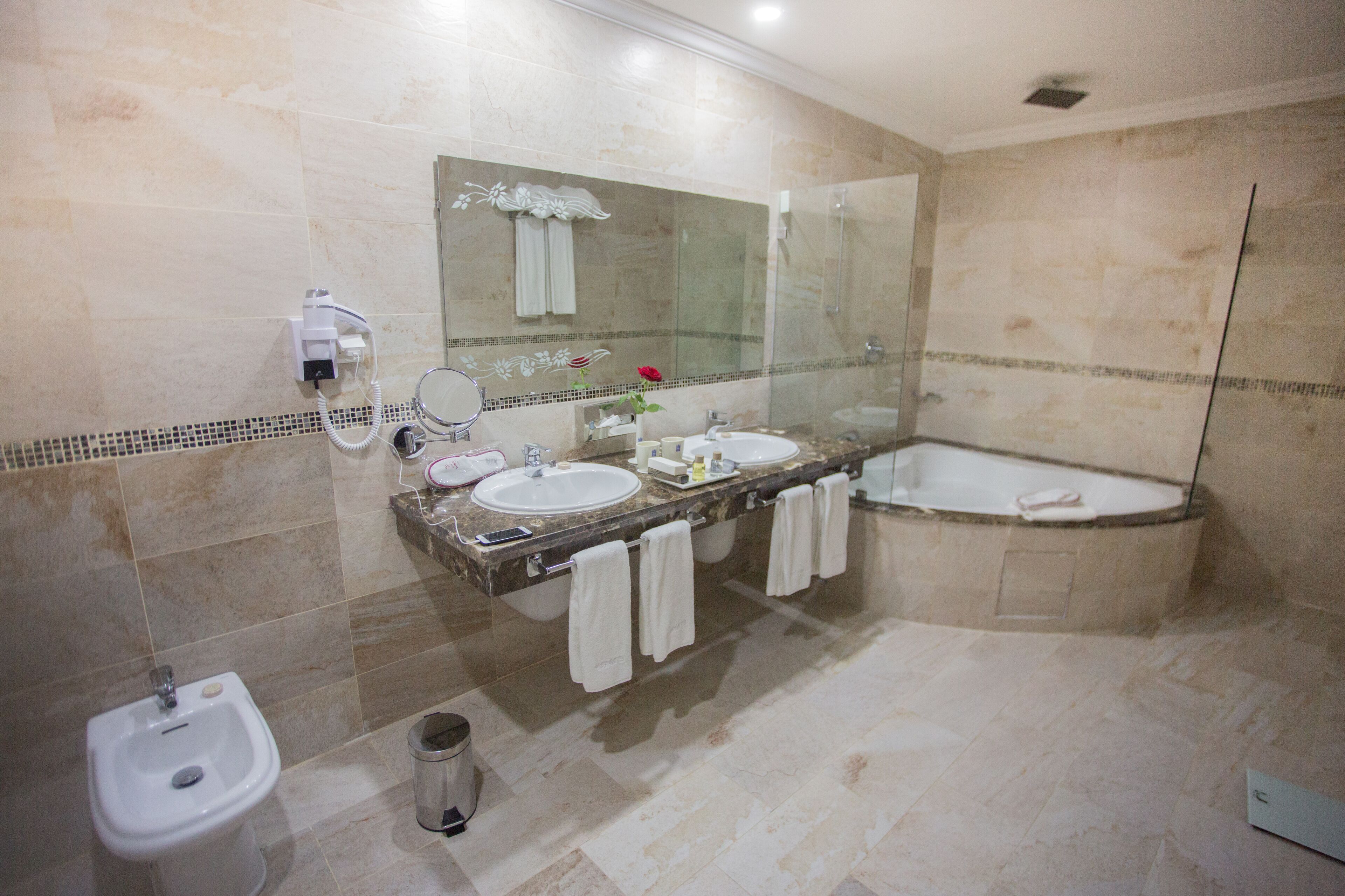 Un bany amb bidet, dues dutxes i un mirall gran.