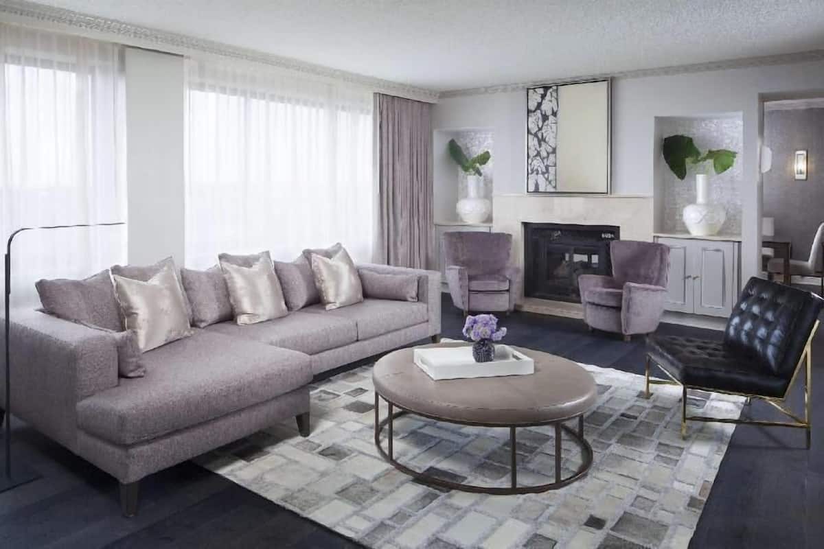 A modern living room with a sectional sofa, a round coffee table, and a fireplace.