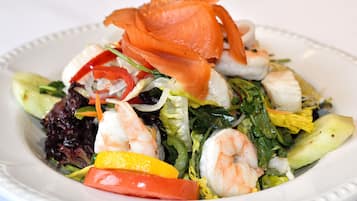 Ein Teller mit Garnelen, Gemüse und geräuchertem Lachs.