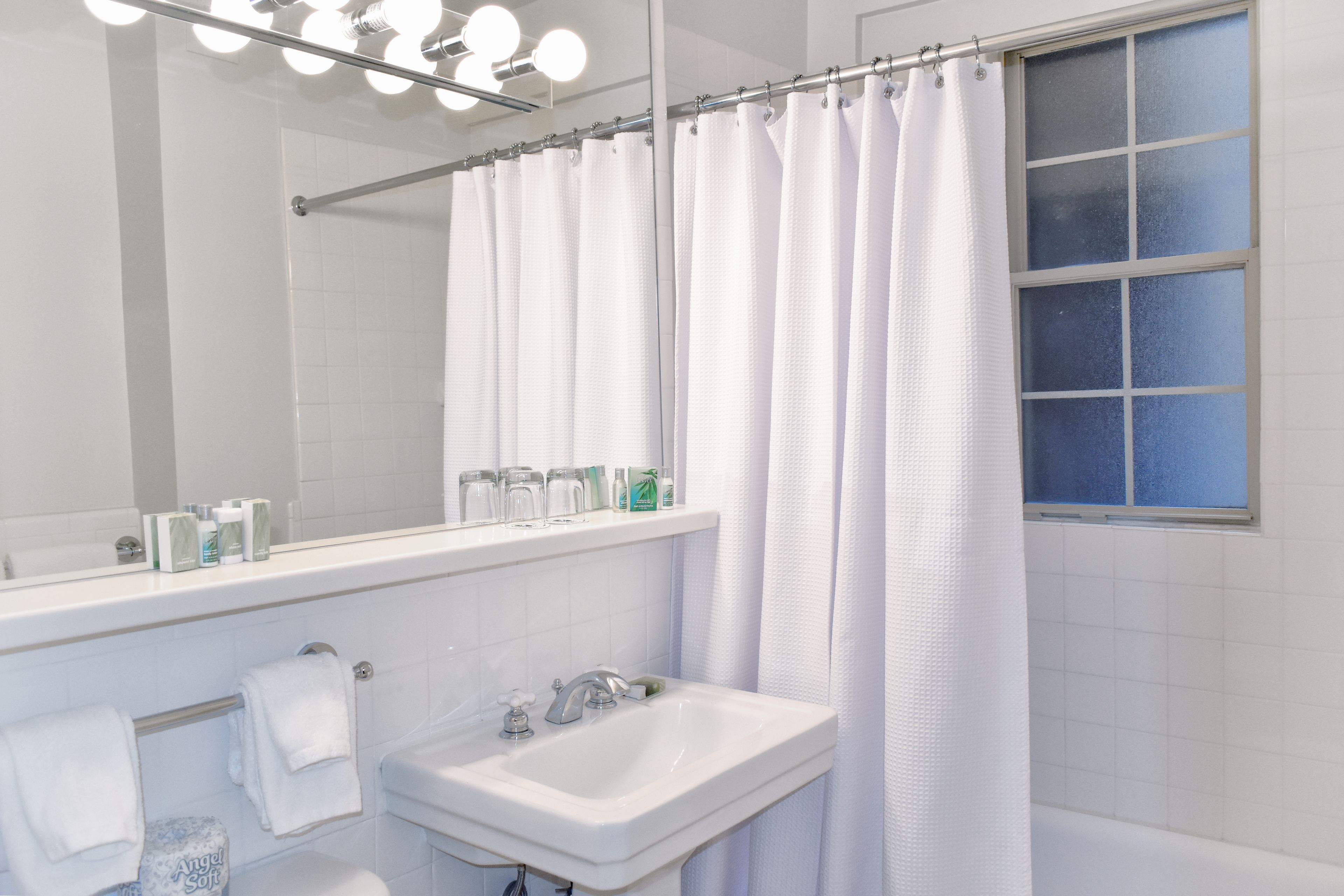 A bathroom with a white sink, a mirror, and a shower curtain.