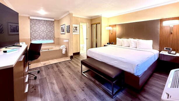 A hotel room with a bed, desk, chair, and a television. - Best Western Hollywood Plaza Hotel - Walk of Fame Film City LA (Los Angeles)