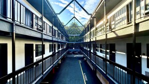 A multi-story building with a central corridor, railings, and a clear sky view. - Best Western Hollywood Plaza Hotel - Walk of Fame Film City LA (Los Angeles)