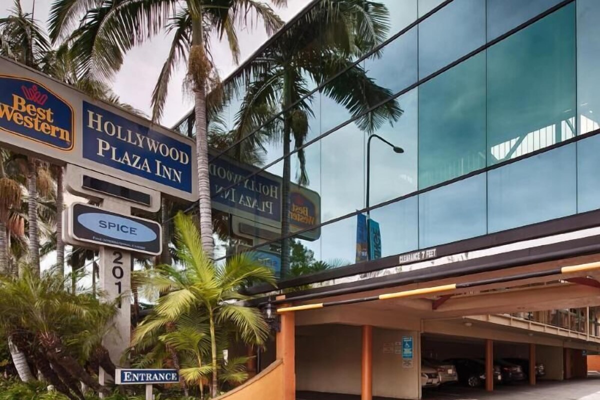 A hotel entrance with signs for Best Western, Hollywood Plaza Inn, and Spice.