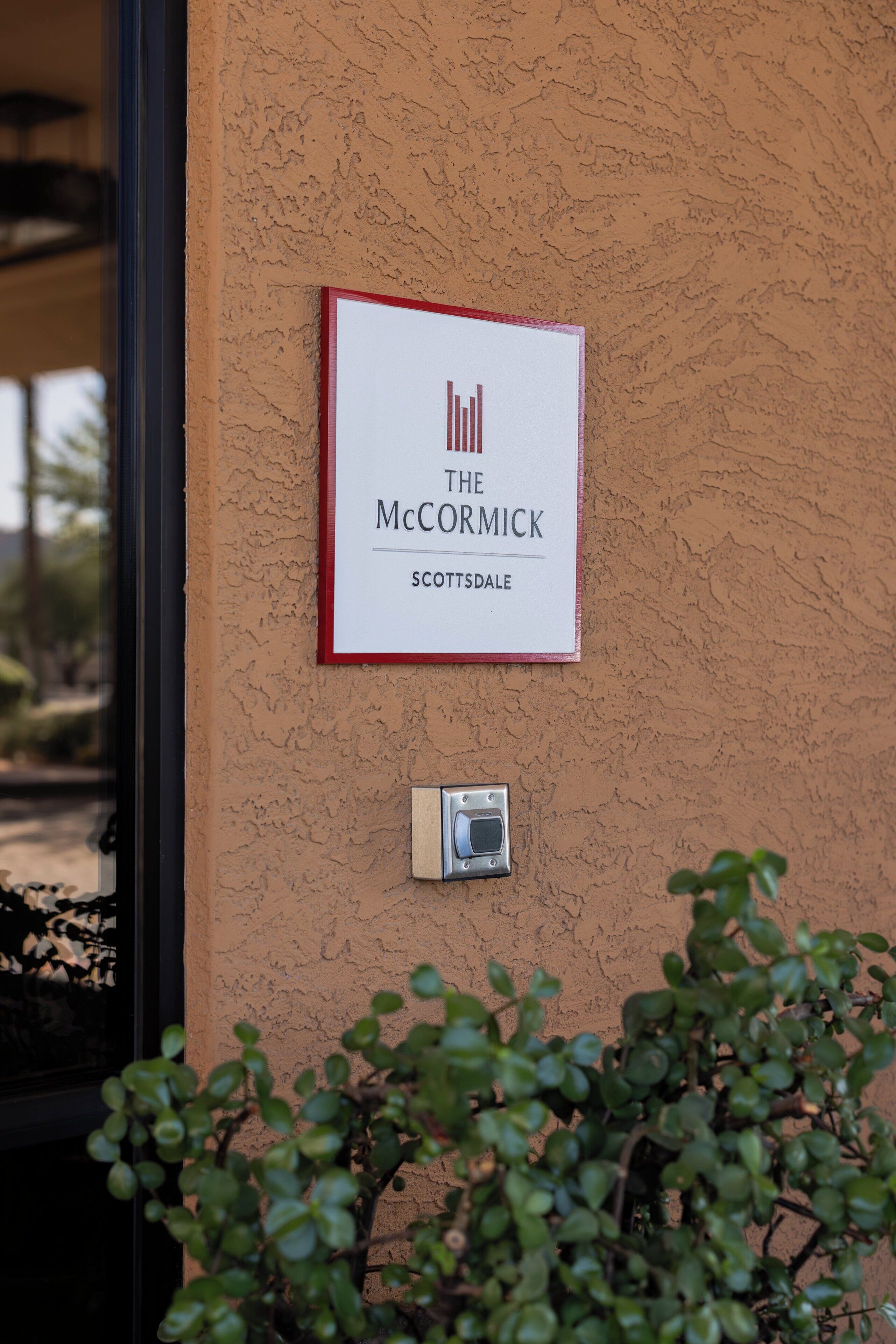 Un cartello su una parete strutturata con la scritta 'THE McCORMICK SCOTTSDALE'.