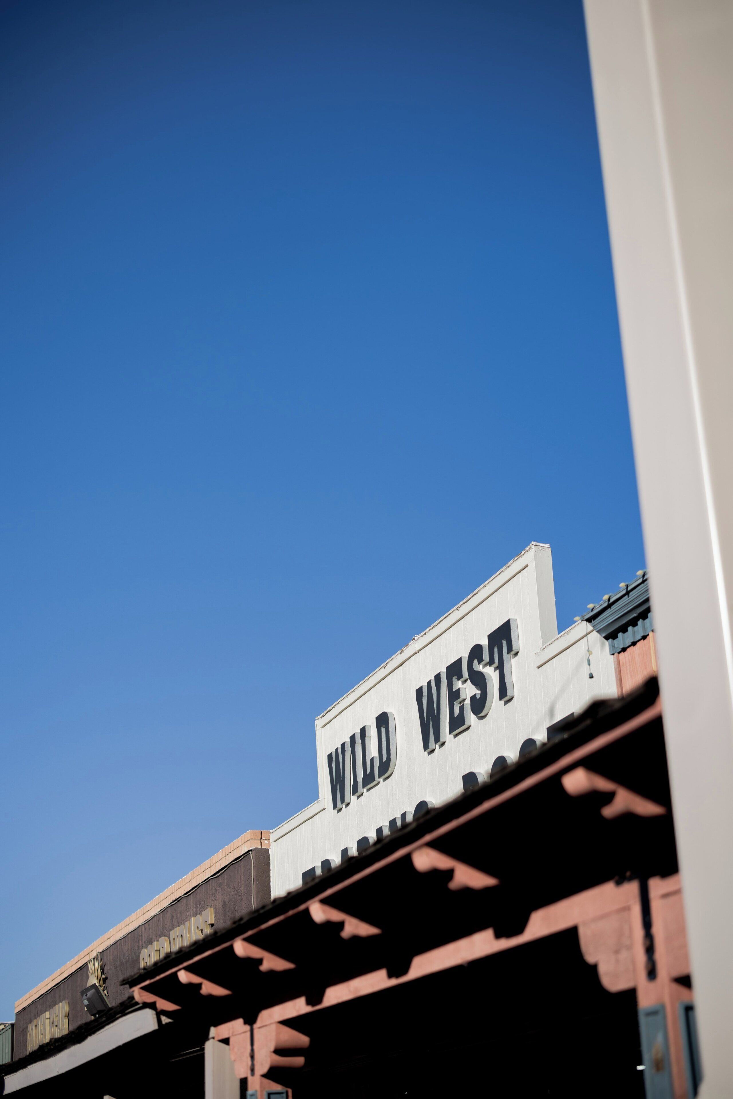A building with a sign reading 'WILD WEST' and a classic architectural style.