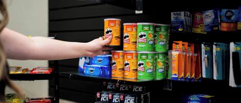 A shelf stocked with various food products including cereal and ice cream.