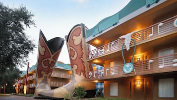 A hotel with a large, colorful sculpture in front, balconies with railings, and a building with a unique design.