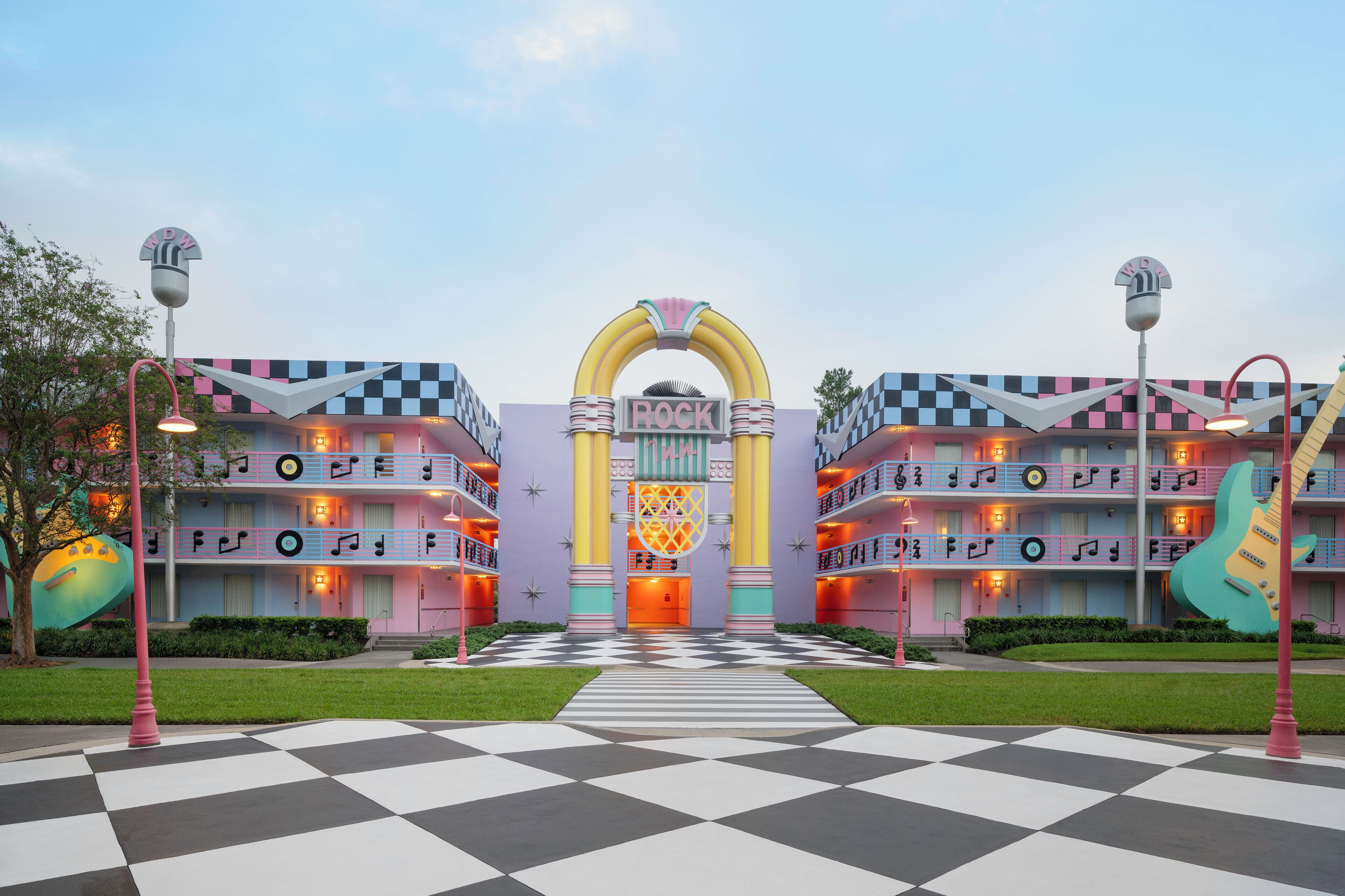 A hotel with a checkered floor, a central archway, and a colorful facade with musical notes.