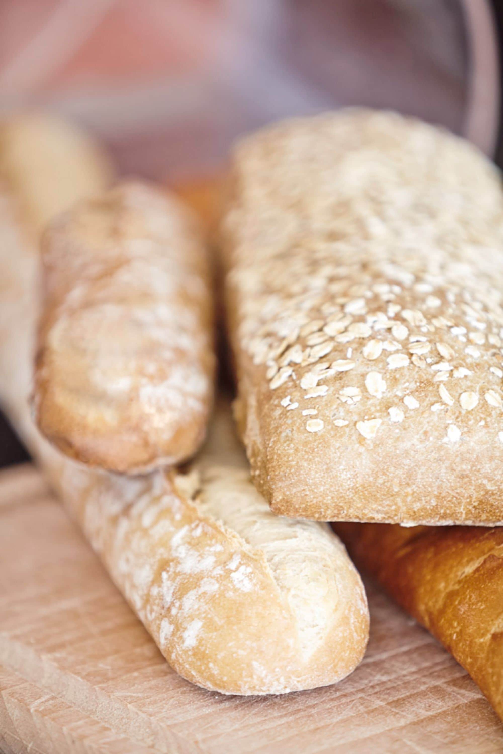 A variety of bread loaves on a wooden cutting board.