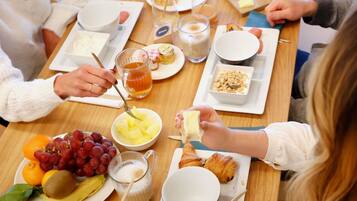 A breakfast setting with various food items and beverages on a wooden table.