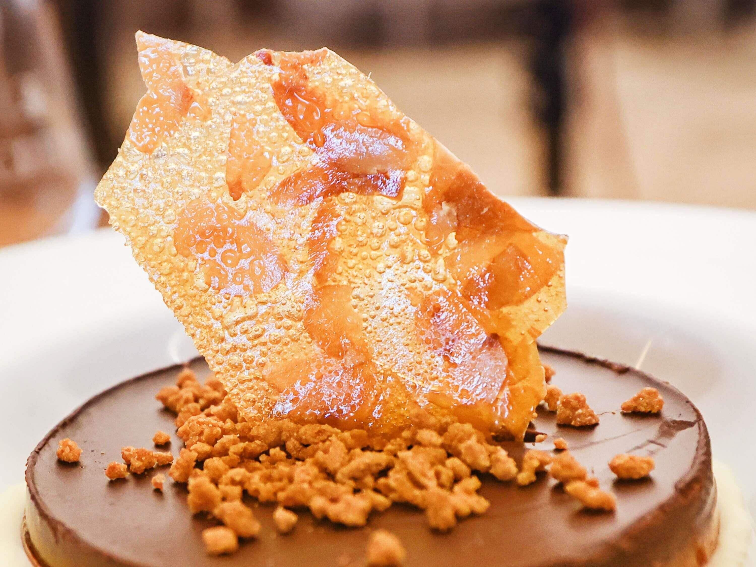 A dessert with a chocolate base, caramelized fruit, and crumbled topping.