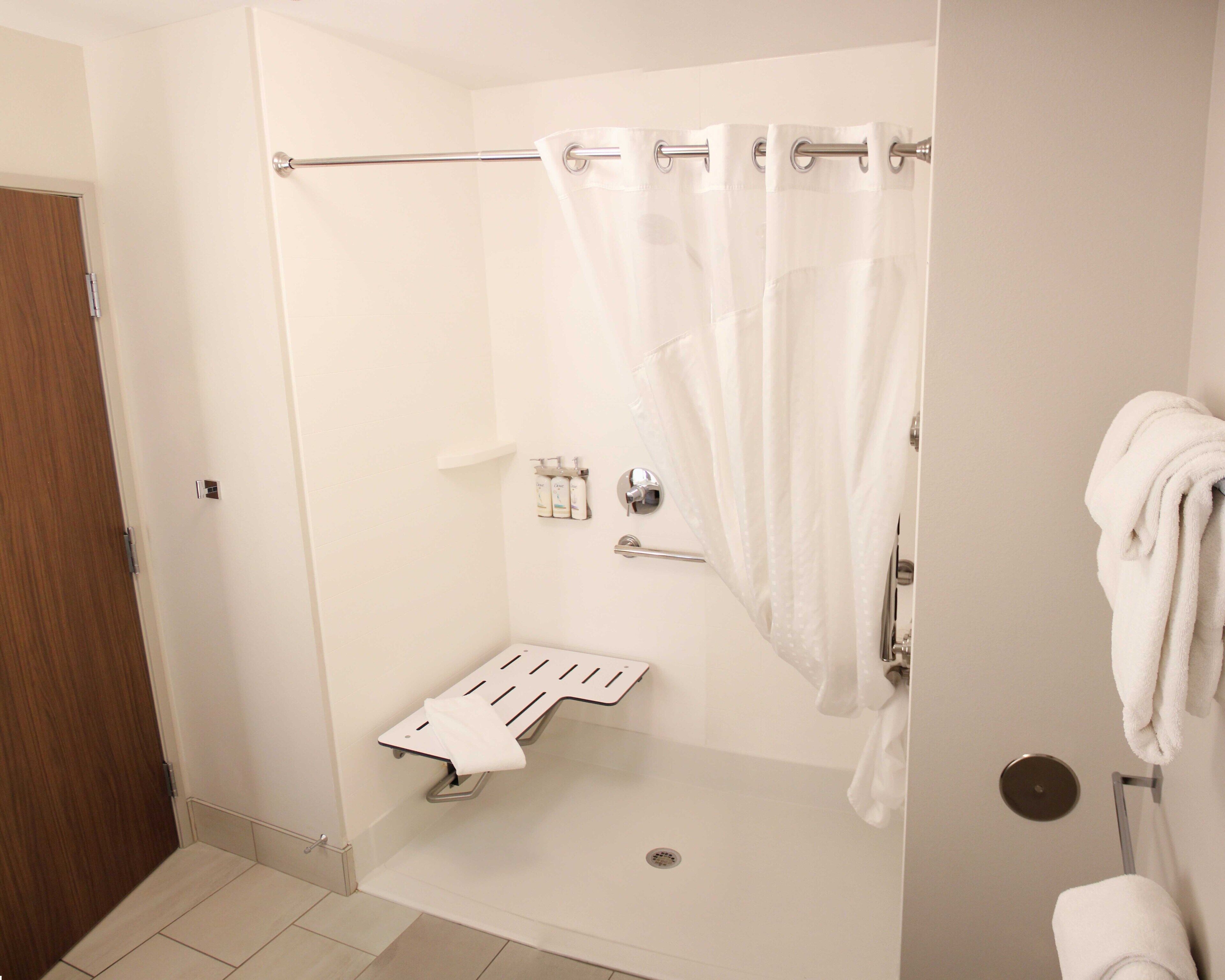 A modern bathroom with a shower, toilet, and towel rack.