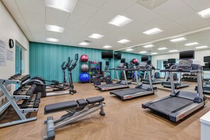 A gym with treadmills, elliptical machines, and free weights.