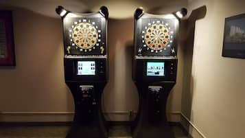 Two dartboards mounted on stands in a hallway.