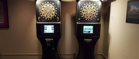 Two dartboards mounted on stands in a hallway.