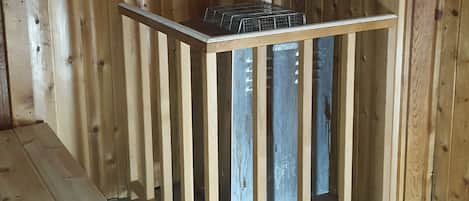 Um quarto de madeira com um banco embutido e uma estante de metal.