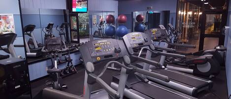 A gym with treadmills, weights, and exercise balls.