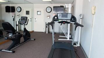 A gym with a treadmill, stationary bike, and exercise equipment.