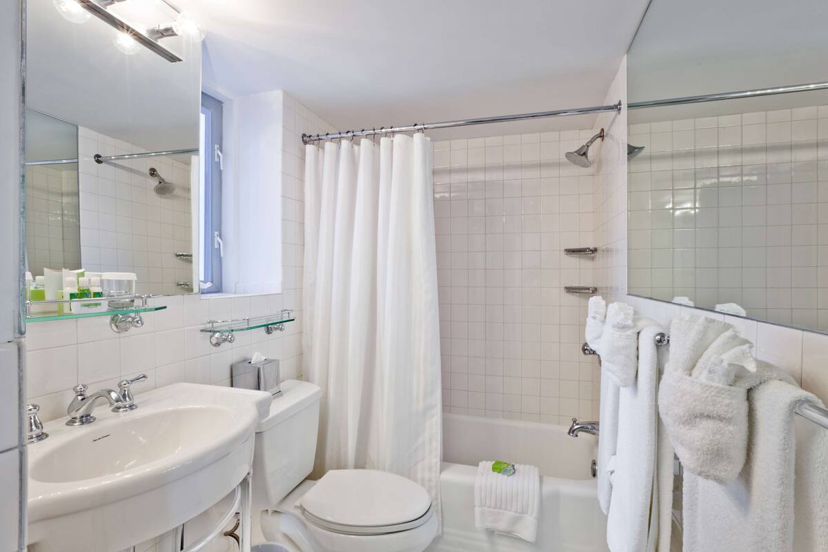 A modern bathroom with a sink, toilet, shower, and bathtub.
