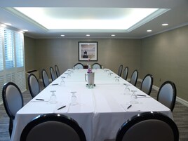 A conference room with a long table, chairs, and a ceiling light.