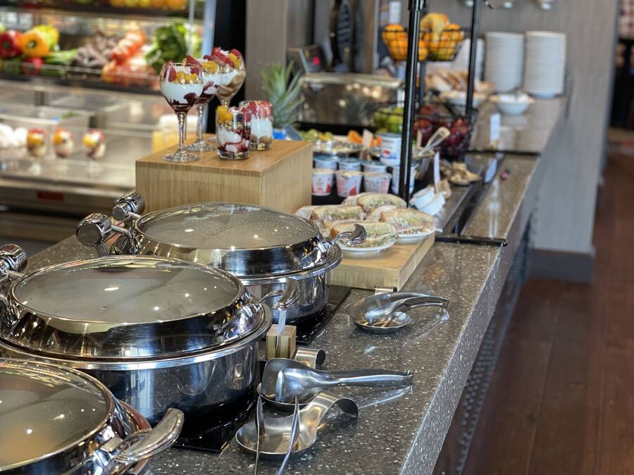 A buffet setup with various food items and serving utensils.