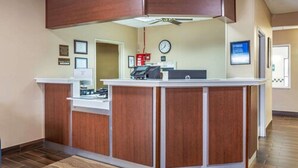 A reception desk with a clock, framed certificates, and a fire extinguisher. - Comfort Inn Rockford near Casino District (Rockford)