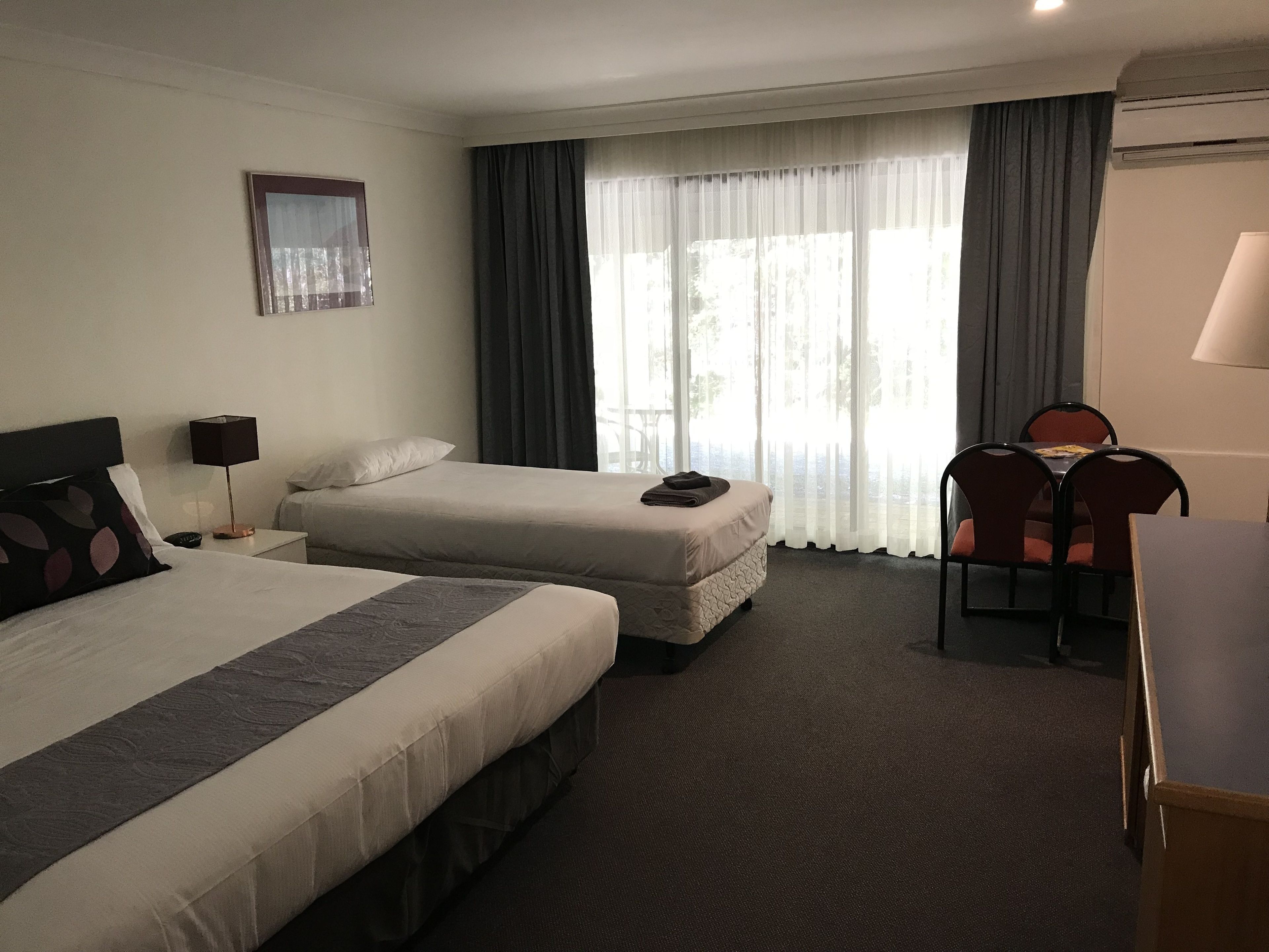 Una habitación de hotel con dos camas, un escritorio y una silla.