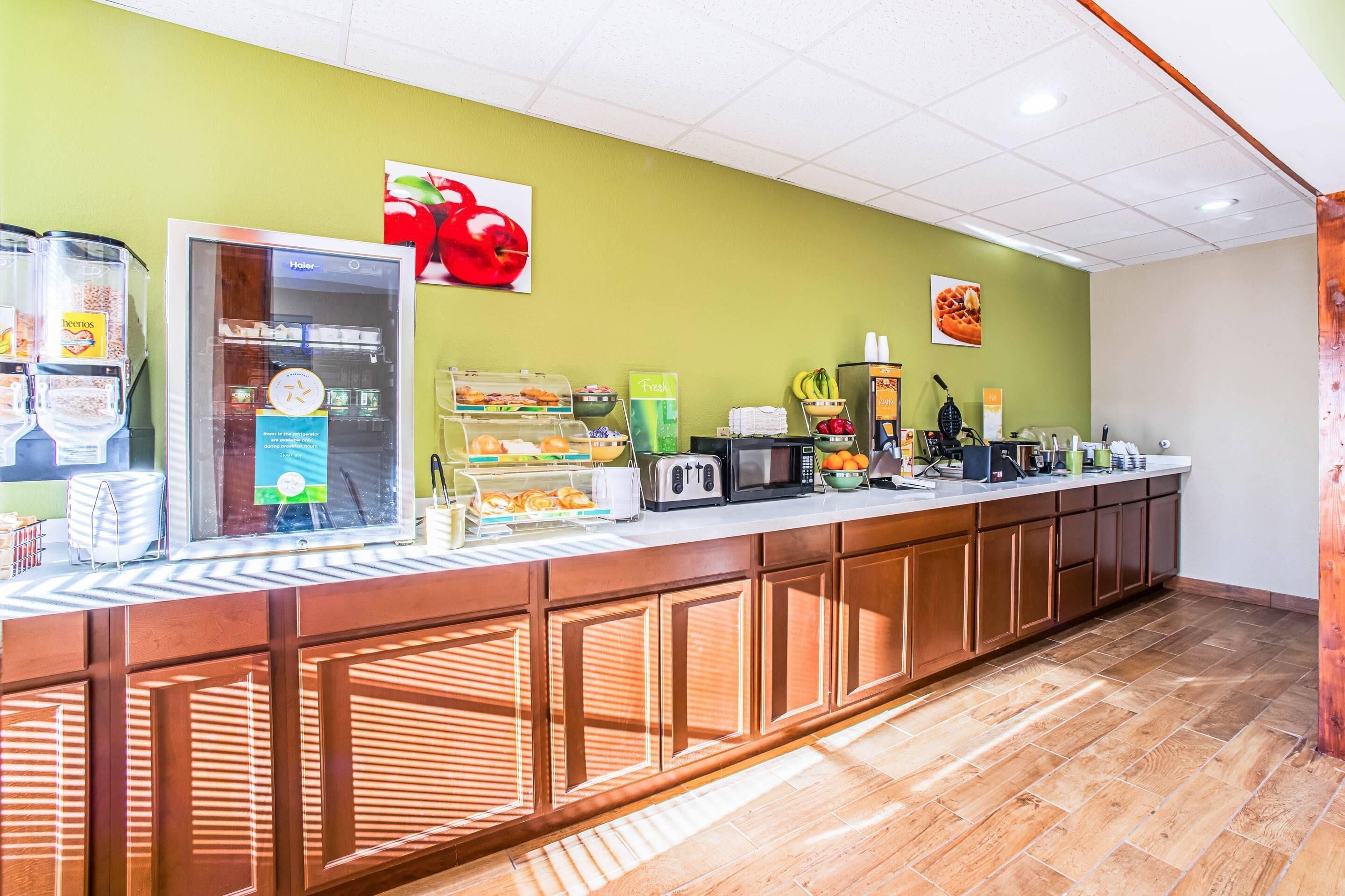 A breakfast bar with various food items and a refrigerator.